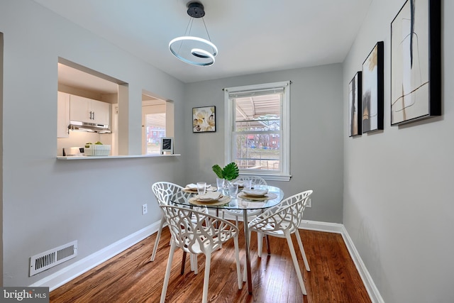 dining room with visible vents, baseboards, and wood finished floors