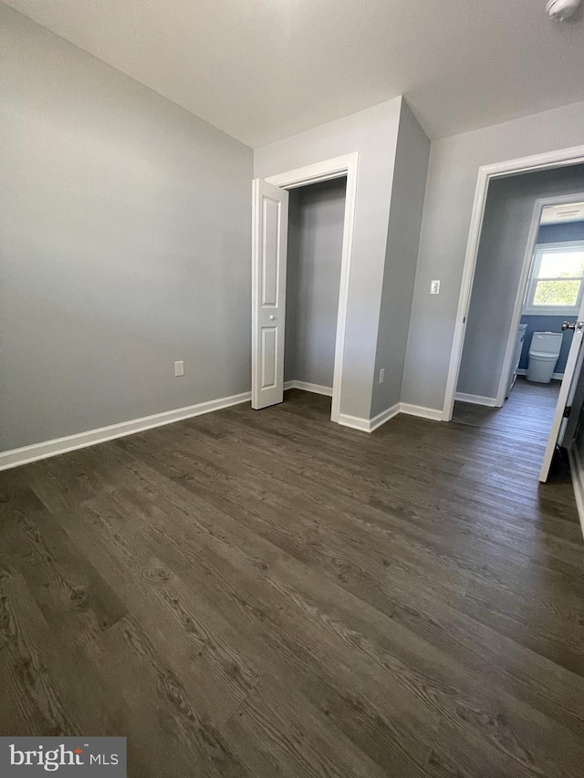 unfurnished bedroom featuring dark wood finished floors and baseboards