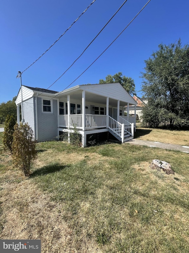 view of front of house featuring covered porch and a front yard