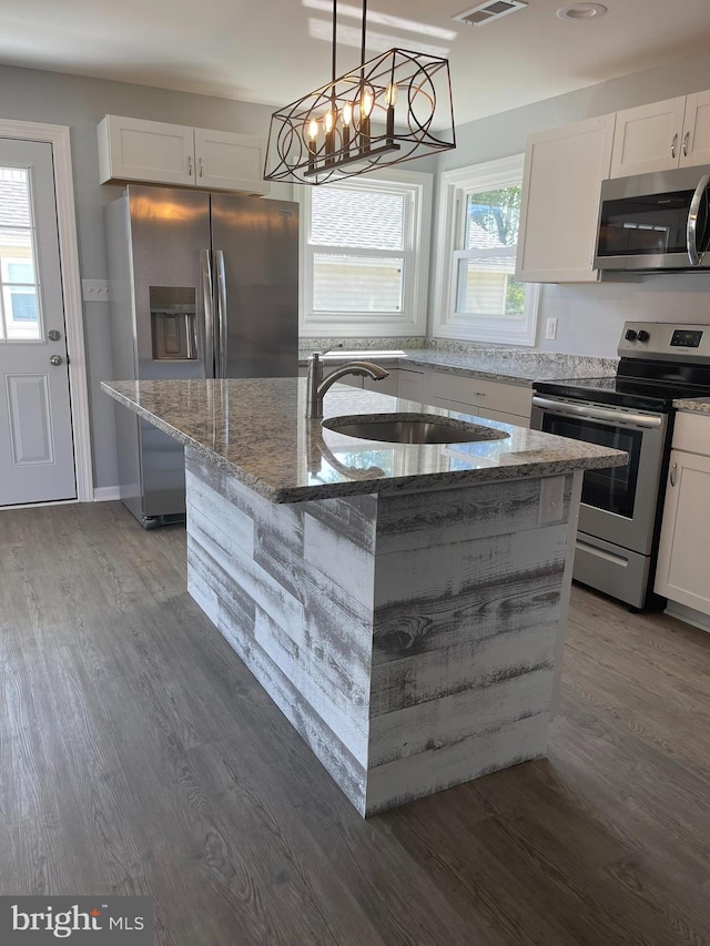 kitchen featuring appliances with stainless steel finishes, stone countertops, a sink, and white cabinets