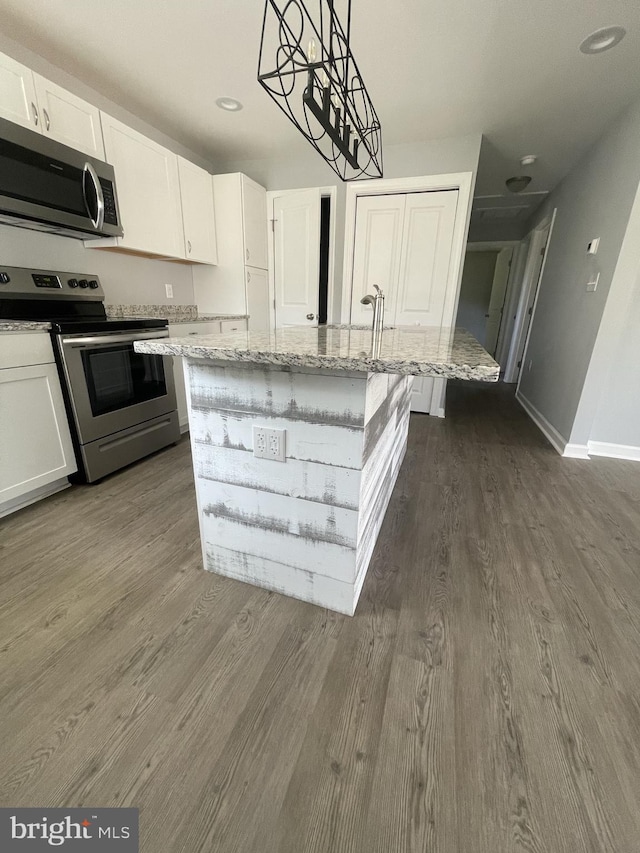 kitchen featuring white cabinets, light stone counters, stainless steel appliances, and dark wood-style flooring