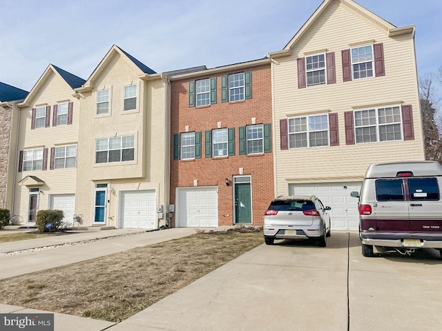 townhome / multi-family property featuring driveway and an attached garage