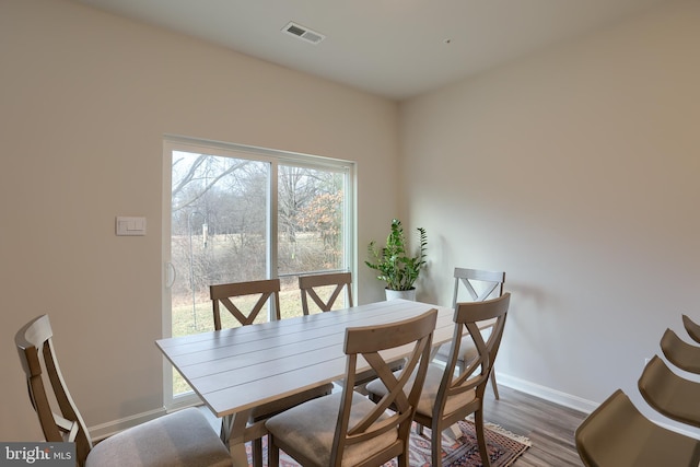 dining room featuring visible vents, baseboards, and wood finished floors