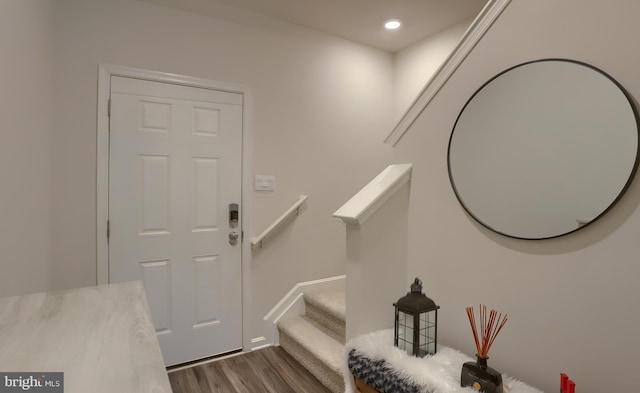 foyer with dark wood-type flooring, stairway, and recessed lighting