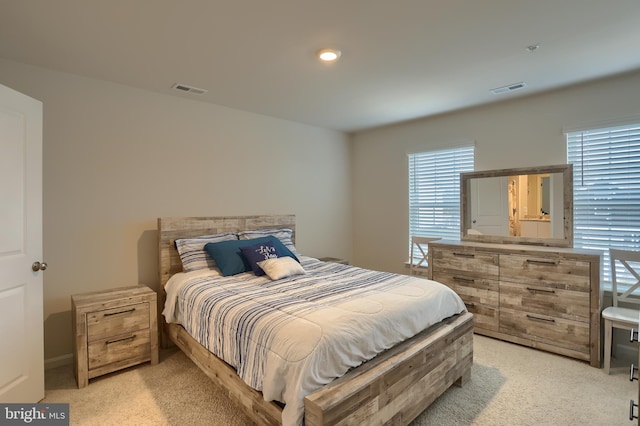 bedroom with visible vents and light carpet