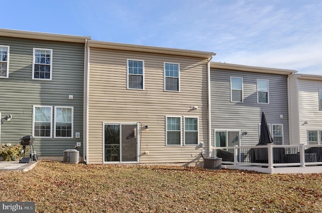 back of property featuring cooling unit and a yard