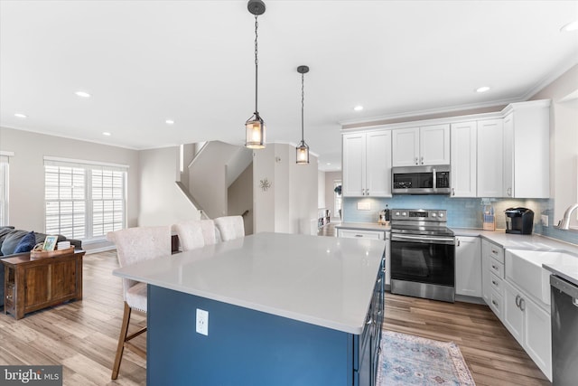 kitchen with stainless steel appliances, backsplash, a breakfast bar area, and ornamental molding