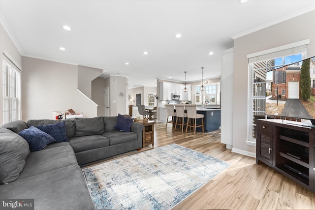 living area featuring crown molding, recessed lighting, light wood-type flooring, and baseboards