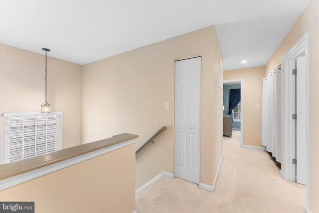 hall featuring recessed lighting, baseboards, an upstairs landing, and light carpet