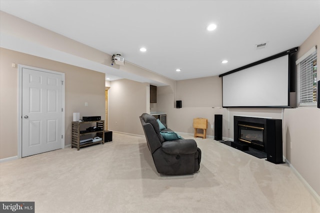 carpeted cinema room with recessed lighting, baseboards, a fireplace with flush hearth, and visible vents