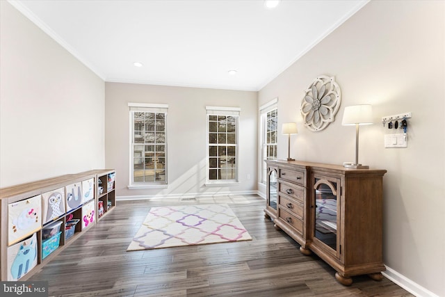 game room with baseboards, wood finished floors, and crown molding