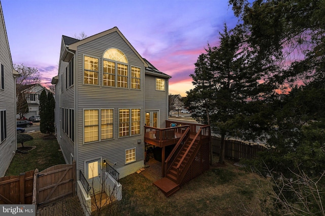 back of property featuring stairway, a gate, fence, and a wooden deck