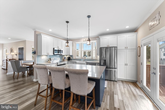 kitchen featuring white cabinetry, visible vents, appliances with stainless steel finishes, and a kitchen island