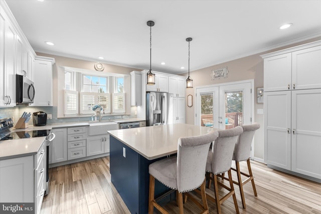 kitchen with a wealth of natural light, decorative backsplash, french doors, stainless steel appliances, and a sink