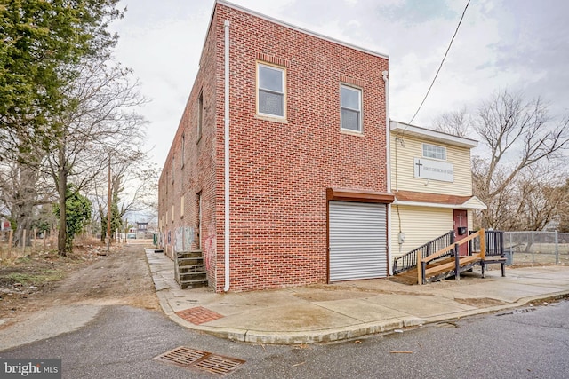 view of front of home with brick siding and fence