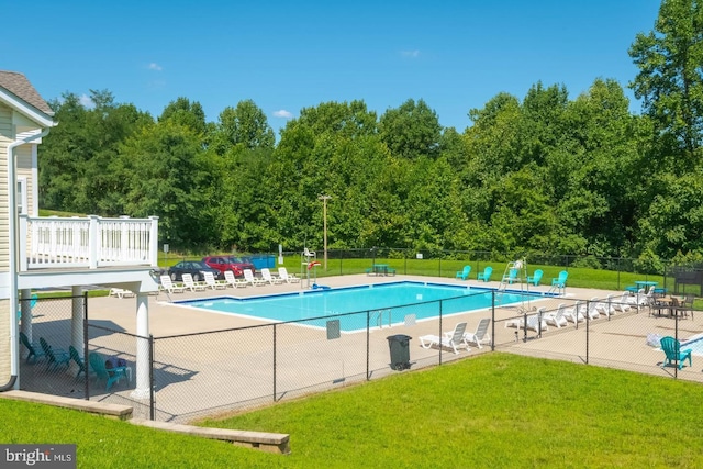 pool with a patio area, fence, and a lawn