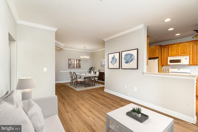 living area with crown molding, recessed lighting, light wood-style flooring, a chandelier, and baseboards