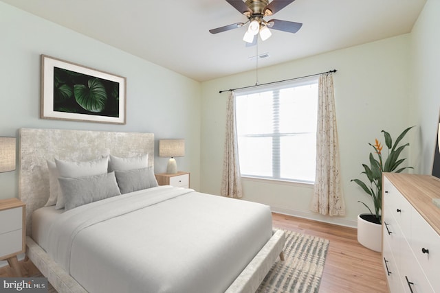 bedroom with a ceiling fan, visible vents, light wood-style flooring, and baseboards