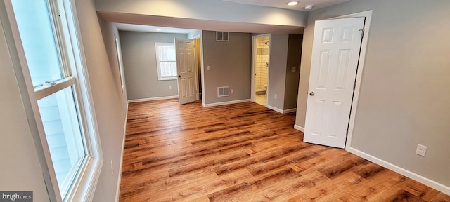 empty room with baseboards, visible vents, and wood finished floors