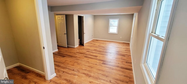 spare room featuring baseboards and wood finished floors