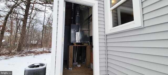 snow covered property entrance featuring central air condition unit