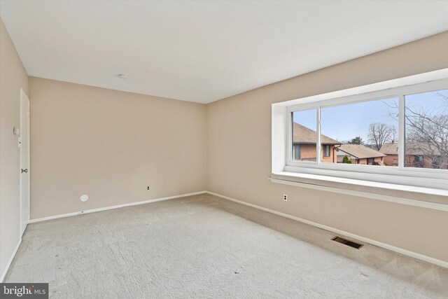 carpeted spare room with baseboards and visible vents