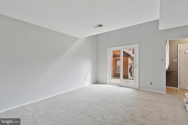 carpeted spare room with visible vents and baseboards