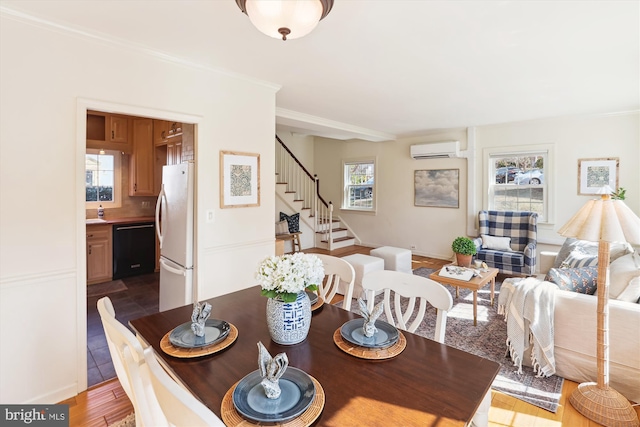 dining room with stairs, ornamental molding, dark wood-type flooring, and a wall mounted air conditioner