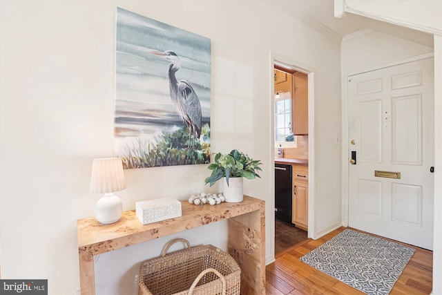 entrance foyer featuring light wood-type flooring and crown molding