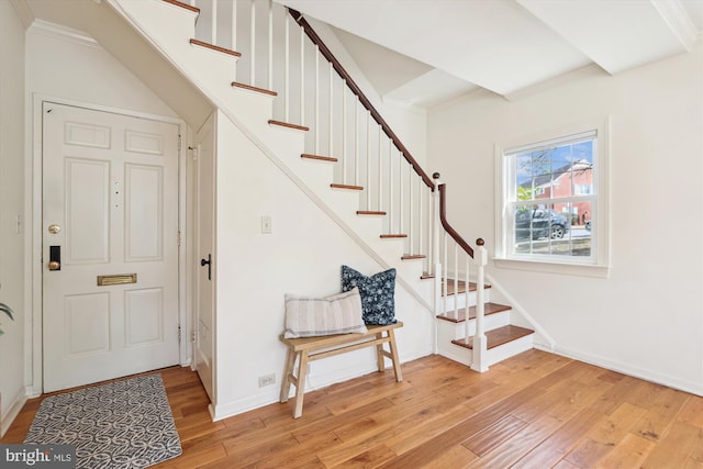 foyer featuring stairs, baseboards, and light wood-style floors