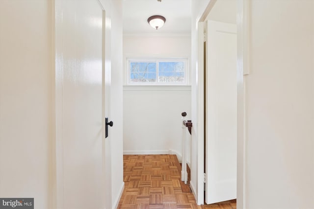 corridor featuring baseboards and crown molding