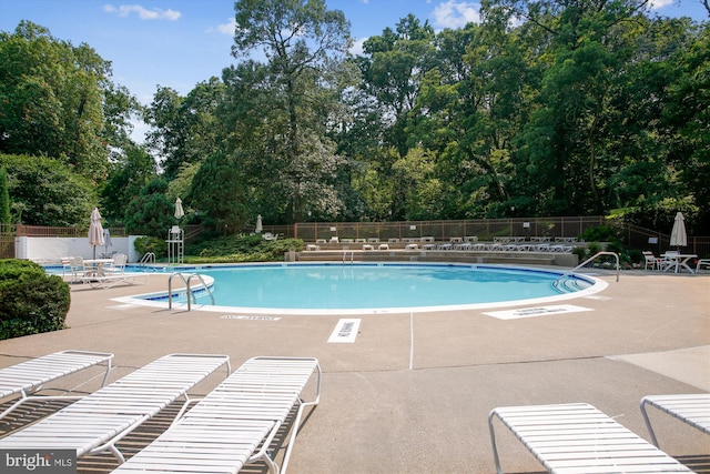 community pool featuring a patio and fence