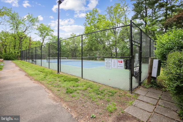 view of sport court featuring fence and a gate