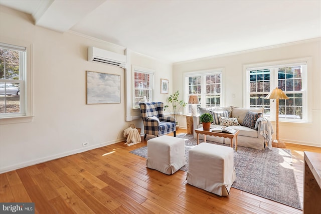 living area with baseboards, ornamental molding, hardwood / wood-style floors, and a wall mounted air conditioner