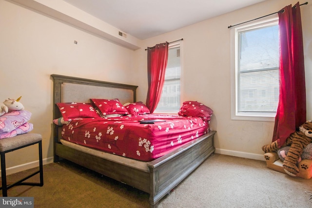 carpeted bedroom with visible vents and baseboards