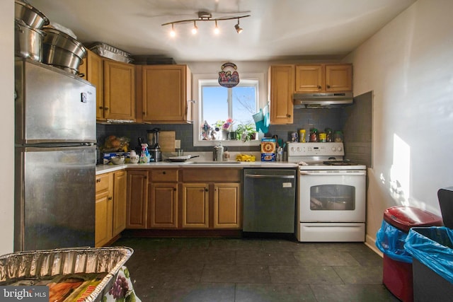 kitchen with decorative backsplash, stainless steel appliances, light countertops, under cabinet range hood, and a sink