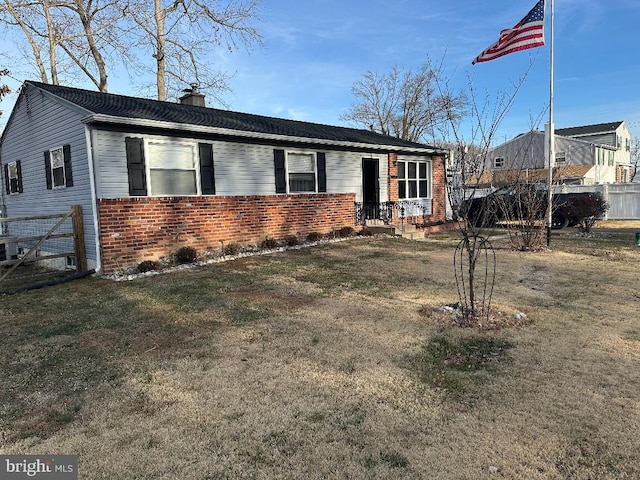 single story home with brick siding, a chimney, a front yard, and fence