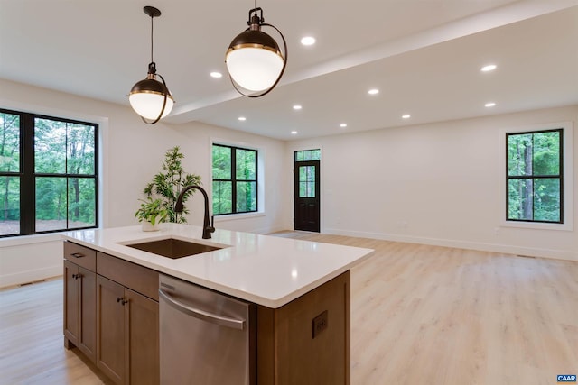 kitchen featuring recessed lighting, light countertops, light wood-style flooring, a sink, and dishwasher