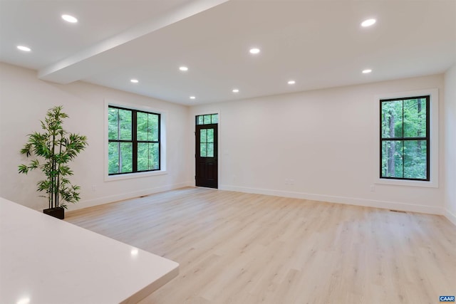 empty room featuring light wood-type flooring, recessed lighting, and a healthy amount of sunlight