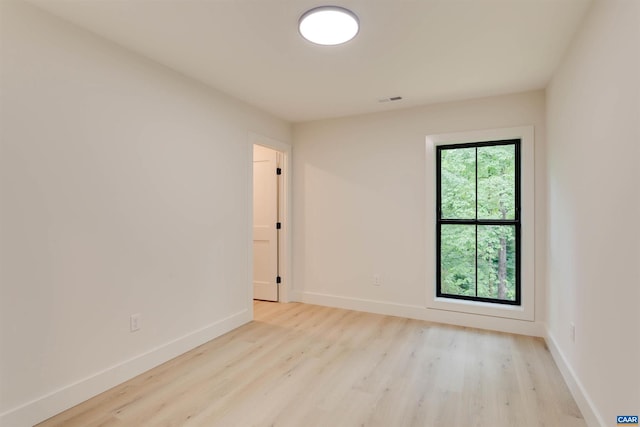 unfurnished room with visible vents, baseboards, and wood finished floors