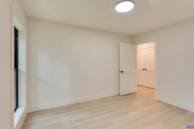 unfurnished room featuring light wood-type flooring and baseboards