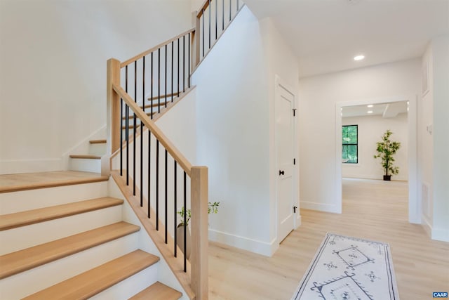 stairway featuring recessed lighting, wood finished floors, visible vents, and baseboards