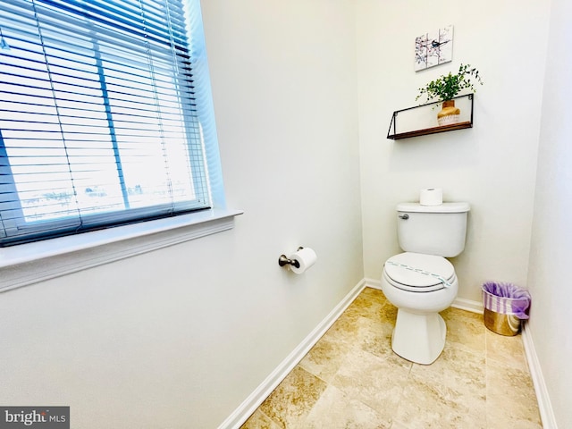 bathroom with tile patterned flooring, toilet, and baseboards