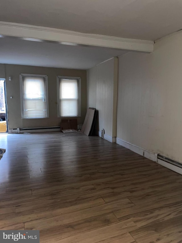 unfurnished room with a baseboard heating unit and wood finished floors