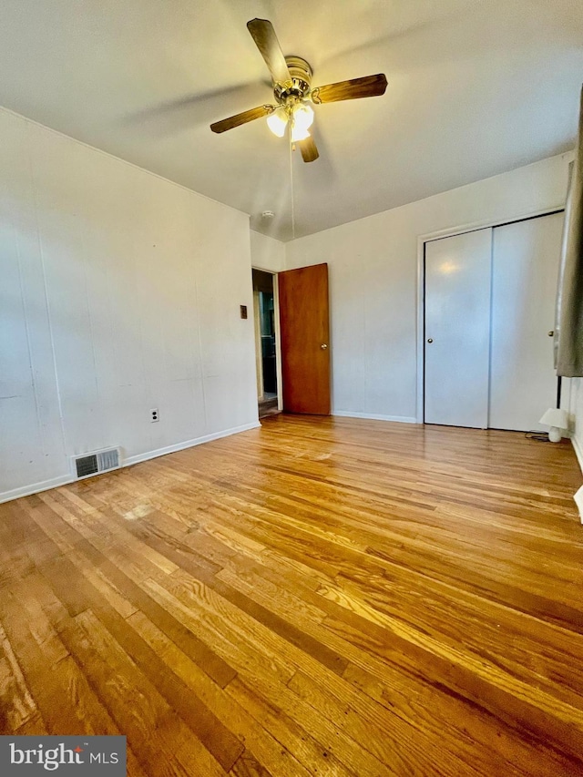 unfurnished bedroom featuring light wood-style floors, ceiling fan, visible vents, and baseboards