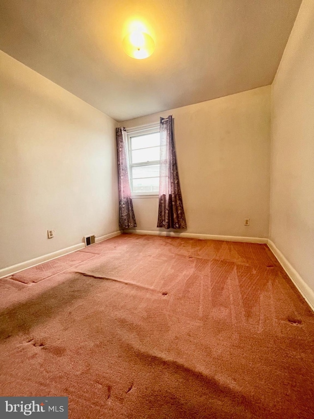 unfurnished room featuring carpet, visible vents, and baseboards