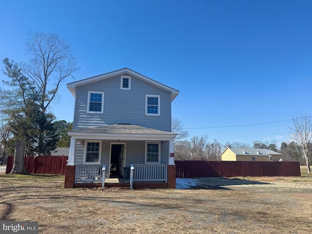 view of front of home featuring fence and a porch