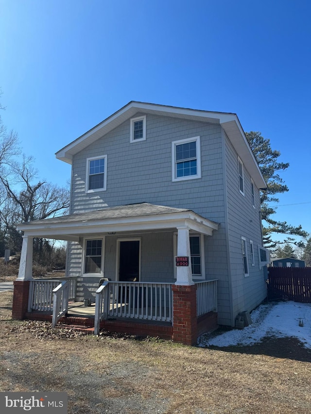 view of front of property with covered porch and fence