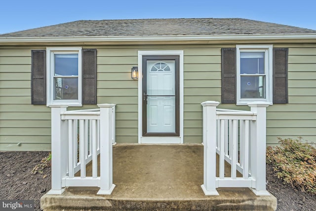 doorway to property featuring a shingled roof