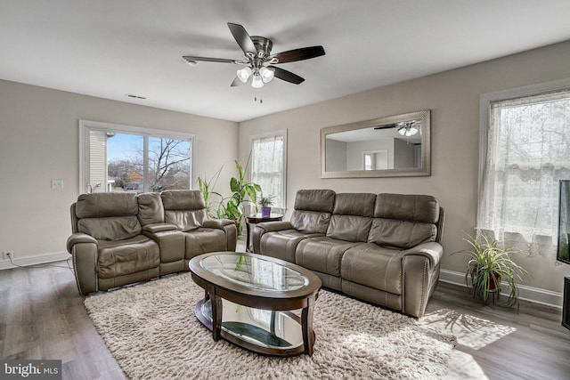 living area with ceiling fan, baseboards, and wood finished floors